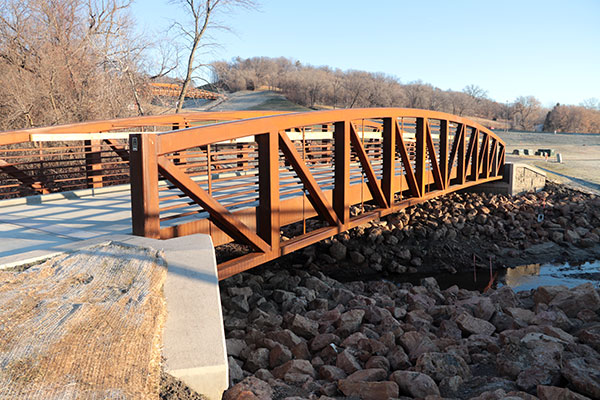 rust-colored bridge over creek and rocks