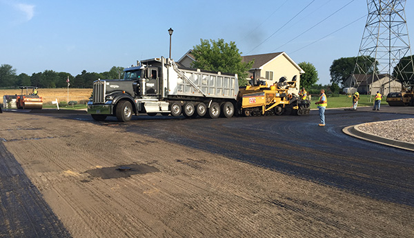 Crews lay new bituminous pavement on street