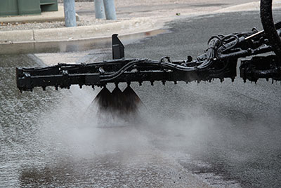 Machine spraying hot liquid on road