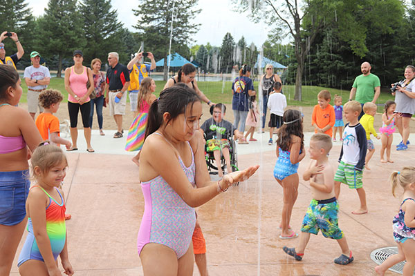 Many kids splash in water spray