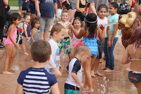 Many kids splash in water spray