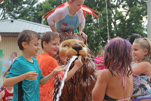 Kids play with Lions head spraying water