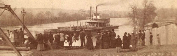 People gathered by bridge with steamboat