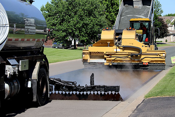 Trucks applying oil and rock